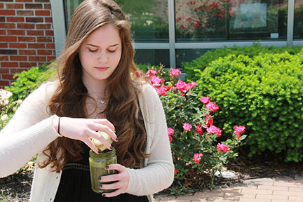 Sitting outside during lunch, sophomore Grace Hermes unscrews her homemade smoothie. Hermes said the Paleo diet consists of meat, vegetables, fruit and nuts. “They call it the caveman diet because the food is clean and not processed,” Hermes said.