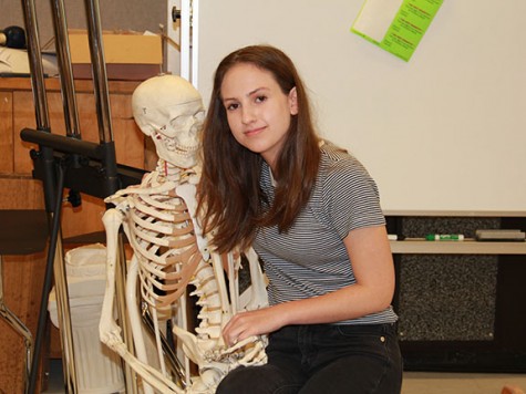  Junior Hampton Williams poses with a skeleton during her independent study, which she spends in room 552. Williams said she doesn’t care about what people think about heer clothing. “I only dress for myself and I do it because I think it’s one of the most expressive forms of art that anyone can do — everything you put on everyday is a statement,” she said. 