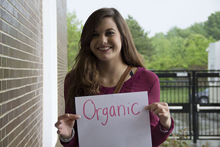 Smiling in the rain, junior Sydney Anderson displays her favor for organic foods. Anderson tried a diet free from processed foods, but decided to revert to a more traditionally healthy diet. “I just make sure to eat my servings of fruit and veggies,” Anderson said