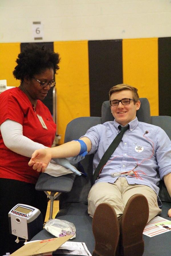 Smiling, senior Tom Overman gets blood drawn for the annual blood drive. This year’s blood drive was Nov. 11. “The blood drive was an easy way to give back to people in need,” he said.
