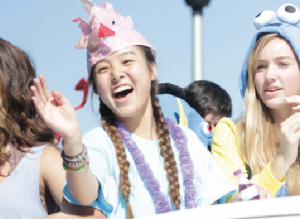 Sophomore Student Council representative Angie Yu waves to the crowd. The parade was Sept. 30. “Whenever we had to work together [on the float,] it was a lot of work especially since it was a small float,” Yu said. “I liked figuring everything out and seeing it all come together.” Photo by Isabelle Allen. 