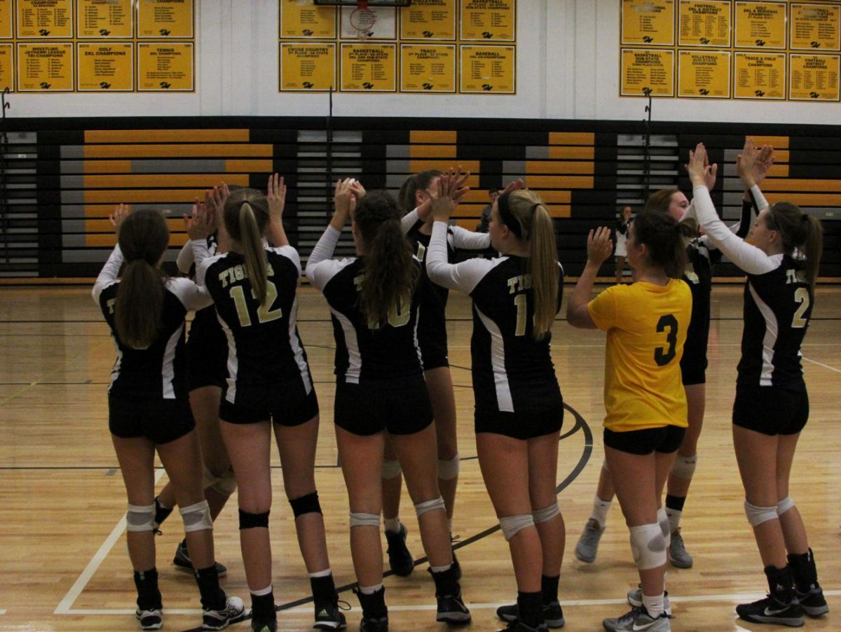 The Varsity girls high-five each other as they energize themselves for the game. Their names were each called over the speakers, and they all threw balls out to the crowd as a part of their pre-game rituals.