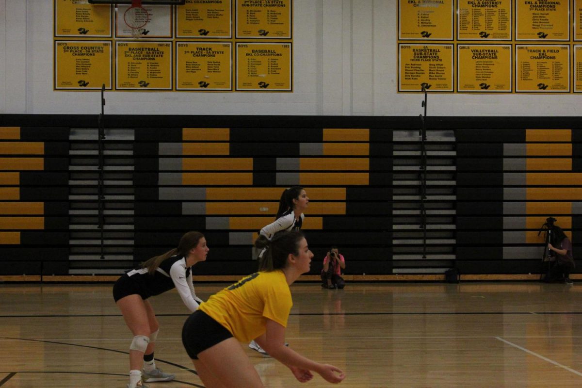 Readying themselves, Allison Tinberg, Evelyn Diederich and Cassidy Carpenter prepare to receive the serve from BV Southwest. Tinberg, wearing the yellow jersey, is the Libero and also a Defensive Specialist for Varsity. 