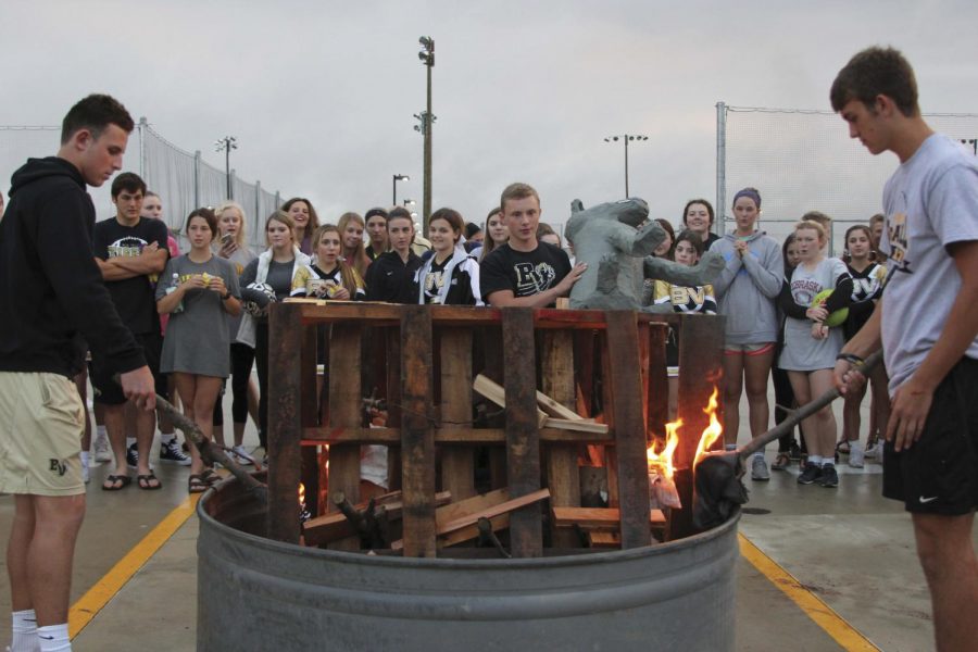 Senior Nick Lester throws the BV Southwest Timberwolf on the fire. Students in National Art Honor Society created the Timberwolf. “[This] is a great way to get everyone excited for the homecoming game,” Lester said.