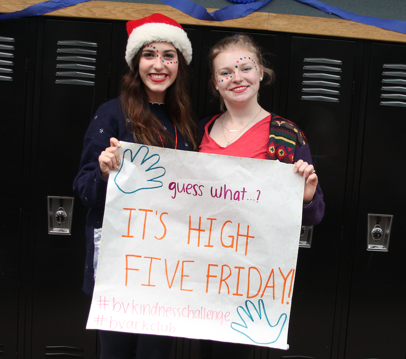 Seniors Ady Shaw (left) and Ally Mosby (right) hold up poster promoting High Five Friday
