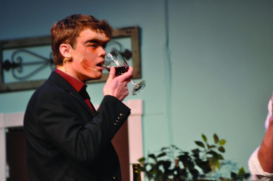Sipping from a glass of wine, junior Adam Pribyl acts in the fall play, ‘Arsenic and Old Lace.’ “I loved it,” he said, “It [was] a great cast of people and it [was] a great time for everyone.”