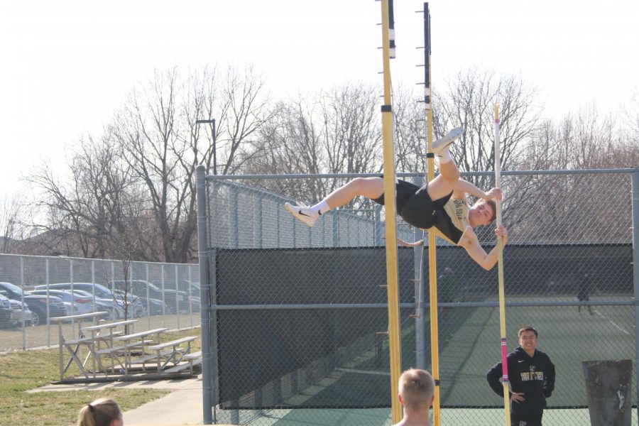 At a meet, freshman Clayton Kavlick pole vaults over a bar. “Learning the form is the hardest part [of pole vaulting],” Kavlick said.