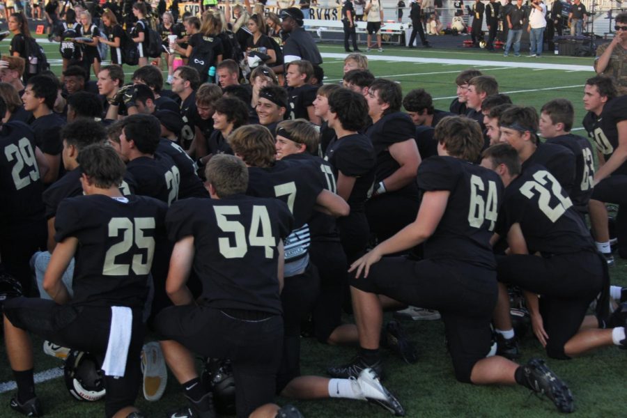 BV football players kneel down to talk with coaches after a big win against Rockhurst.