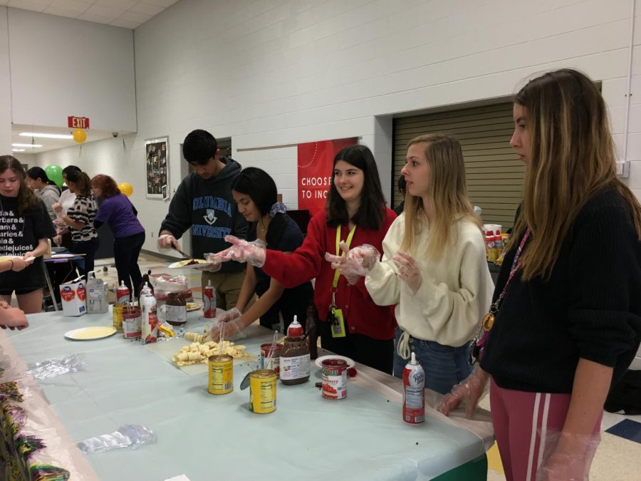 Sophomores and NFHS members Kylie Mac Ewen and Ivy Miller prepare middle schoolers crepes.